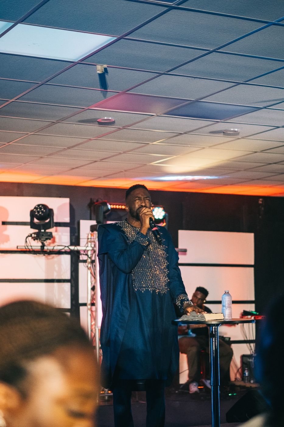 Worship leader singing under warm light
