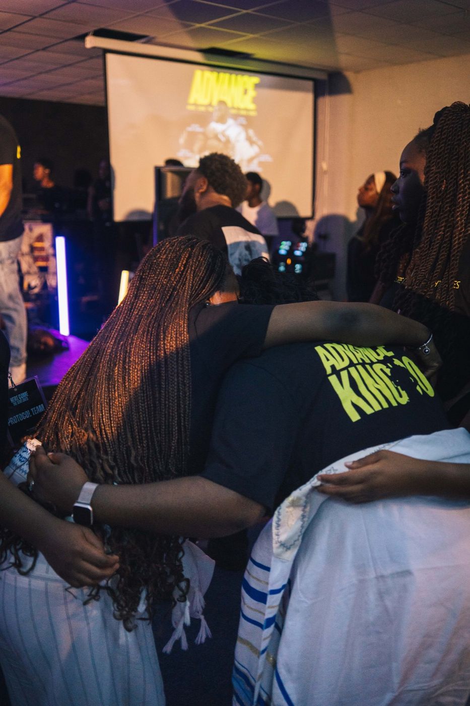Friends embracing in prayer at a MORE Youth night