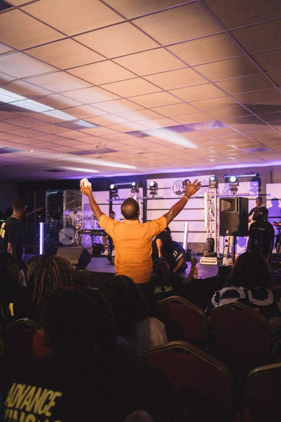 A young man with arms stretched wide in worship